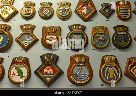 Ausstellung von vielen Abzeichen der Royal Navy Schiffe im Nothe Fort Museum, Weymouth, Dorset, UK Stockfoto