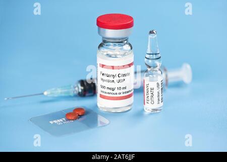 Fentanyl Citrat-Injektionsampule, Durchstechflasche, klarer Fentanyl Dermal Patch, Tabletten und Spritze auf blauem Tablett Stockfoto