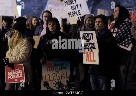 City, Iowa, USA. Januar 2020. Demonstranten halten Zeichen und Gesang, während Präsident DONALD TRUMP auf einem großen Videomonitor außerhalb des Drake University knapp Center während einer Wahlwiederholung am 30. Januar 2020 spricht. Die Anhänger standen auf den Straßen, während Demonstranten auf dem nahe gelegenen Parkplatz skandierten. Kredit: Fritz Nordengren/ZUMA Wire/Alamy Live News Stockfoto