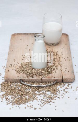 Vegane pflanzenbasierte Milchalternativen. Hanfsaatmilch mit Hanfsamen auf einem Holzbrett Stockfoto