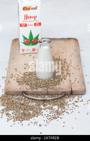 Vegane pflanzenbasierte Milchalternativen. Vegane Milchalternativen. Hanfsaatmilch mit Hanfsamen auf einem Holzbrett Stockfoto