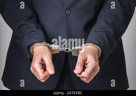 Ein Mann in Anzug und Handschellen. Konzept zum Thema Festnahme eines Beamten. Stockfoto