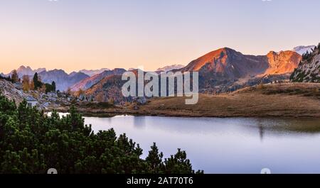 Frühmorgendliche Bergkulisse der Alpin. Ruhiger Valparola Pfad und Blick auf den See, Belluno, Italien. Malerisches Reisen, saisonal und na Stockfoto