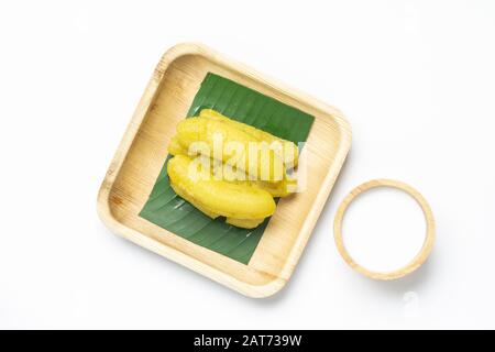 Thailändisches Dessert Banana in Sirup, süßes Dessert in Thailand. Konservierte Lady Finger-Bananen oder goldene Bananen mit Sirup in recyceltem Nuß Palmblattform mit Witz Stockfoto