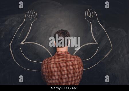 Foto des Mannes Rücken. Zwei starke muskulöse Arme auf dem Schwarzen Brett gemalt Stockfoto