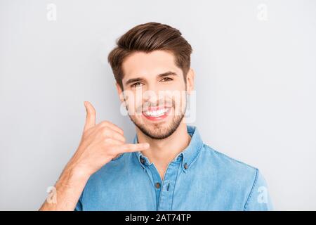 Verspielt lächelnder junger Kerl, der ihn anruft Stockfoto