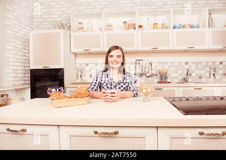 Porträt einer lächelnden Frau, die Kaffee mit gebackenen Kuchen trinkt Stockfoto