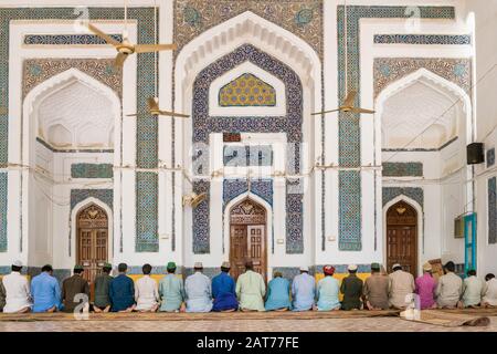 Bunte Linie muslimischer Männer, die am Schrein von Hazrat Makhdoom Sarwar Nooh in Hala, Sindh, Pakistan beten Stockfoto