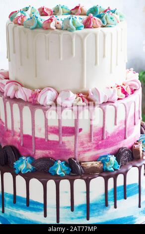 Dreifach gestufter Farbkuchen mit farbigen Schmutzflecken aus Schokolade auf hellem Hintergrund. Bild für ein Menü oder einen Süßwarenkatalog, den Hochzeitstorte Stockfoto