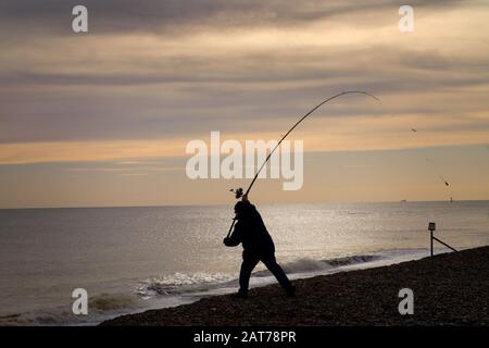 Silhouette des Menschen Angeln am Aldeburgh Beach, Aldeburgh, Suffolk. Stockfoto