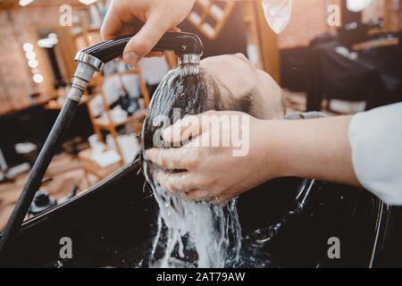 Haarstylisten waschen Klientelhaar im barber Shop Stockfoto