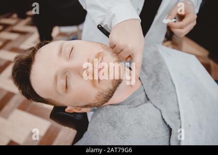 Barber Process Rasieren Rasiermesser bärtiger Flusspferd im Barbershop Stockfoto