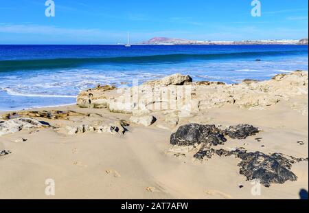 Blick auf den schönen Strand von Papagayo in der Stadt Playa Blanca, Lanzarote, Kanarische Inseln. Blick auf blaues Meer, gelber Sand, selektiver Fokus Stockfoto