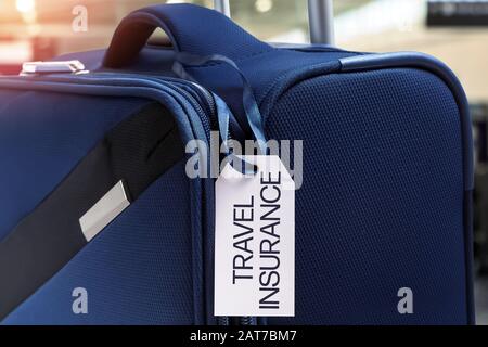 Blauer Koffer mit Reiseversicherungsaufkleber Stockfoto