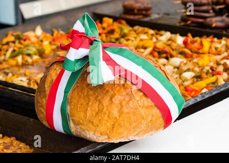 Traditionelles festliches ungarisches Brot, das mit der Flagge Ungarns gefesselt ist. Stockfoto