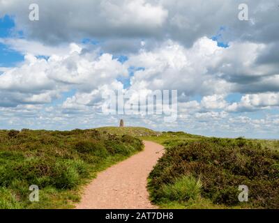 Der abgerundete Gipfel und der trig-Punkt von Beacon Batch on Black Den höchsten Punkt der Mendip Hills Somerset UK hinunter Stockfoto