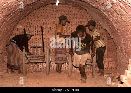 Arbeiter, die Transport, feuerten Ziegelsteine in einem Ringofen einer Ziegelfabrik in der Nähe von Luang Prabang, Laos Stockfoto