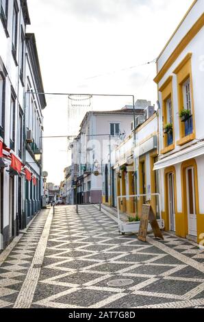 Ponta Delgada, Azoren, Portugal - 12. Januar 2020: Leere Straße mit Bars und Restaurants im historischen Zentrum der portugiesischen Stadt. Bunte Fassaden, traditionelle Häuser, gepflasterte Straßen. Stockfoto