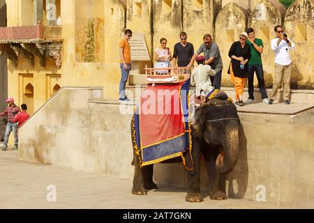 Amer, Indien - 16. August 2016: Einige Touristen warten darauf, auf den Elefanten im Amber Fort in Amer, Rajasthan, Indien zu kommen. Das Amer oder Amber Fort erhebt sich Stockfoto