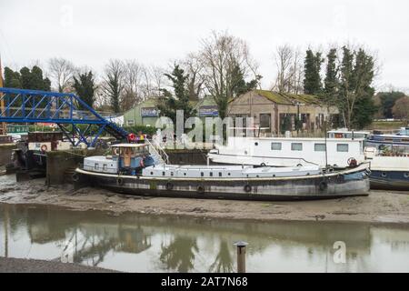 John's Boat Works Ltd,- bunte Hausboote, die auf Lot's Ait an der Themse gegenüber dem Waterman's Arts Center, Brentford, London, Großbritannien repariert werden Stockfoto