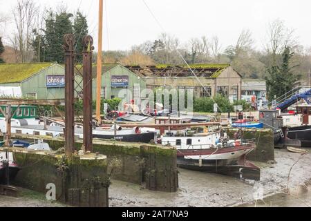 John's Boat Works Ltd,- bunte Hausboote, die auf Lot's Ait an der Themse gegenüber dem Waterman's Arts Center, Brentford, London, Großbritannien repariert werden Stockfoto