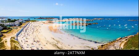 Panoramaaussicht über den Strand von Greve Blanche in Tregastel, Bretagne, an einem sonnigen Tag mit Menschen zum Sonnenbaden und zum genießen des türkisfarbenen Meeres. Stockfoto