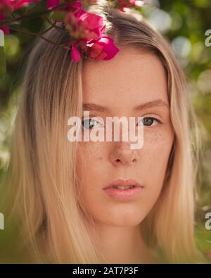 Blondes Mädchen-Porträt mit Blumen Stockfoto