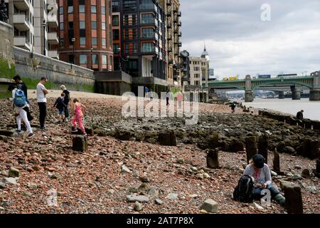 Mudlarks an der Themse vor Ebbe, in der Nähe der Millennium Bridge, London. Stockfoto