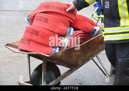 Mecklenburg-Vorpommern, Deutschland. Januar 2020. Schläuche liegen in einer Schubkarre, während Feuerwehrleute einen Brand aus zwei Produktionshallen auf dem Gelände eines Holzverarbeitungsunternehmens in Ueckermünde löschen. Insgesamt wurden zwei Hallen zerstört, in denen unter anderem Verarbeitungsmaschinen und auch Boote im Winterlager gelagert wurden. Foto: Stefan Sauer / dpa-Zentralbild / dpa Credit: Dpa Picture-Alliance / Alamy Live News Stockfoto