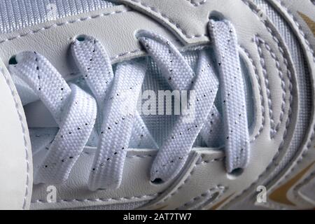 Teil eines weißen Sneakers mit Schnürsenkeln. Ein Fragment von Lederschuhen. Stockfoto