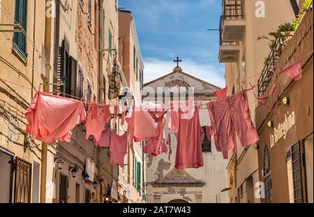 Rosa wäsche Anzeige verwendet lokalen Restaurant zu werben, auf die Via Principe Umberto, der historischen Zentrum von Alghero, Provinz Sassari, Sardinien, Italien Stockfoto