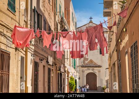 Rosa wäsche Anzeige verwendet lokalen Restaurant zu werben, auf die Via Principe Umberto, der historischen Zentrum von Alghero, Provinz Sassari, Sardinien, Italien Stockfoto