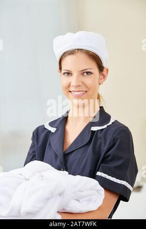 Lächelnde Magd in Uniform im Hotel Stockfoto