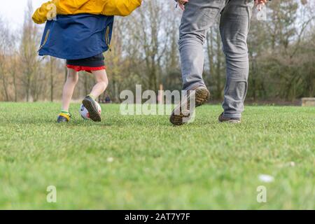 Vater und Sohn genießen ein Fußballspiel im Park. Stockfoto