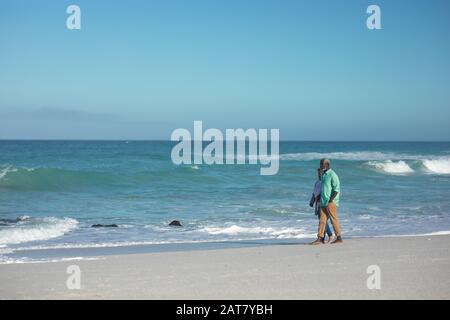 Altes Paar, das am Strand spazieren geht Stockfoto