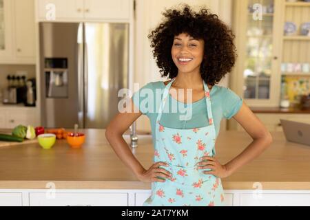 Junge Frau mit Schürze in der Küche Stockfoto