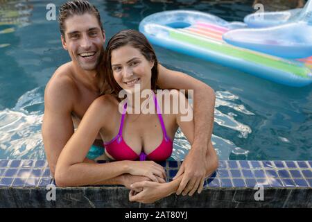 Glückliches junges Paar, das sich im Swimmingpool erholt Stockfoto