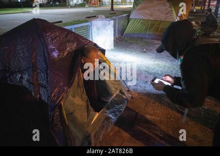 Austin, Texas, USA. Januar 2020. Obdachlose Männer beantworten Fragen am frühen Morgen als Freiwillige mit Austins Umfrage zur Endung der Community Obdachlose Coalition (ECHO) in der jährlichen Point-In-Time-Zählung obdachloser Bevölkerungsgruppen in Texas. Eine wachsende Obdachlose Präsenz, die unter Brücken und in öffentlichen Räumen lebt, hat Bedenken hinsichtlich Austins Erschwinglichkeit geäußert, wenn sein Wachstum zuneigt. Gutschrift: Bob Daemmrich/ZUMA Wire/Alamy Live News Stockfoto