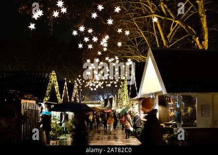 Deutscher Weihnachtsmarkt in der Nacht mit Marktständen und beleuchteten Sternen Stockfoto