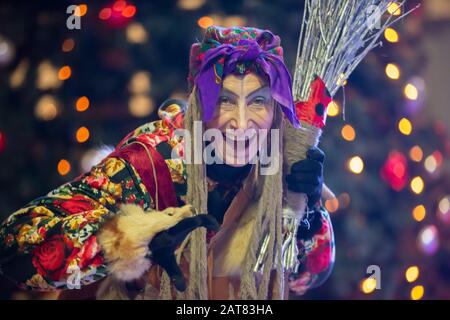 Baba Yaga mit einem Besen auf dem Hintergrund des Weihnachtsbaums. Stockfoto