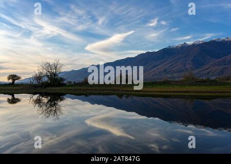 Blick auf den Kerkini-See mit Lichtreflexionen auf das Wasser bei Sonnenuntergang im Norden Griechenlands. Stockfoto