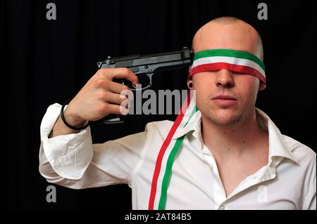 Junger Mann mit verbundenen Augen in weißem Hemd mit Pistole an den Kopf Stockfoto