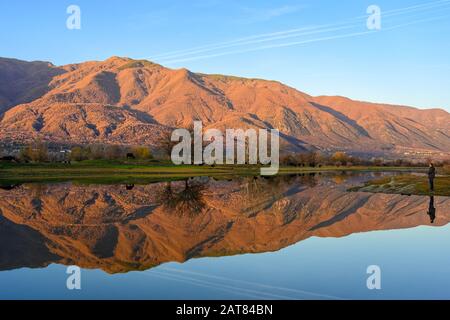 Blick auf Kerkini See mit Reflexionen auf dem Wasser bei Sonnenuntergang im Norden Griechenlands. Fotograf versuchen, eine Herde Wasserbüffel zu erfassen Stockfoto