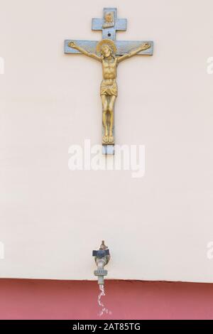 Kreuz mit Jesus und Hahn mit heiligem Wasser. Religion. Stockfoto