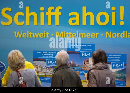 Dresden, Deutschland. Januar 2020. Besucher der Reisemesse stehen auf einem Kreuzfahrtausstellungsstand vor einem Plakat mit den Worten "Hüfte Ahoy! Vom 31. Januar bis 2. Februar 2020 präsentieren rund 400 Aussteller weltweit verschiedene Reiseziele. Kredit: Sebastian Kahnert / dpa-Zentralbild / dpa / Alamy Live News Stockfoto