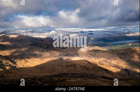 Dramatischer Winterblick vom Gipfel des Ben Lomond in Richtung Loch Lomond und den Gipfeln der Arrochar-Alpen in den schottischen Highlands. Stockfoto