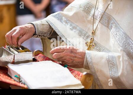 Orthodoxe Religion. Hände des Priesters auf der bibel. Stockfoto