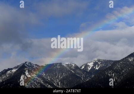 Garmisch Partenkirchen, Deutschland. Januar 2020. Über dem Gipfel des hohen Ziegspitz ist ein Regenbogen zu sehen. Credit: Angelika Warmuth / dpa / Alamy Live News Stockfoto