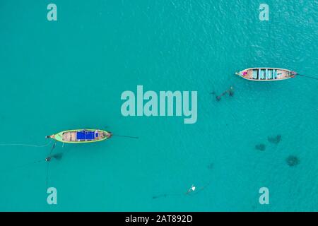 Luftbild oder Draufsicht über Langschwänzchen schwimmt auf dem smaragdgrünen Meer. Ruhiger andamansee in Phuket, Thailand. Kata Strand Stockfoto