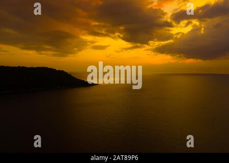 Blick auf den Sonnenuntergang über dem Meer, Phuket, Thialand. Sonnenuntergang über dem Meer. Ruhige idyllische Szene mit goldenem Sonnenuntergang über dem Meer mit r Stockfoto